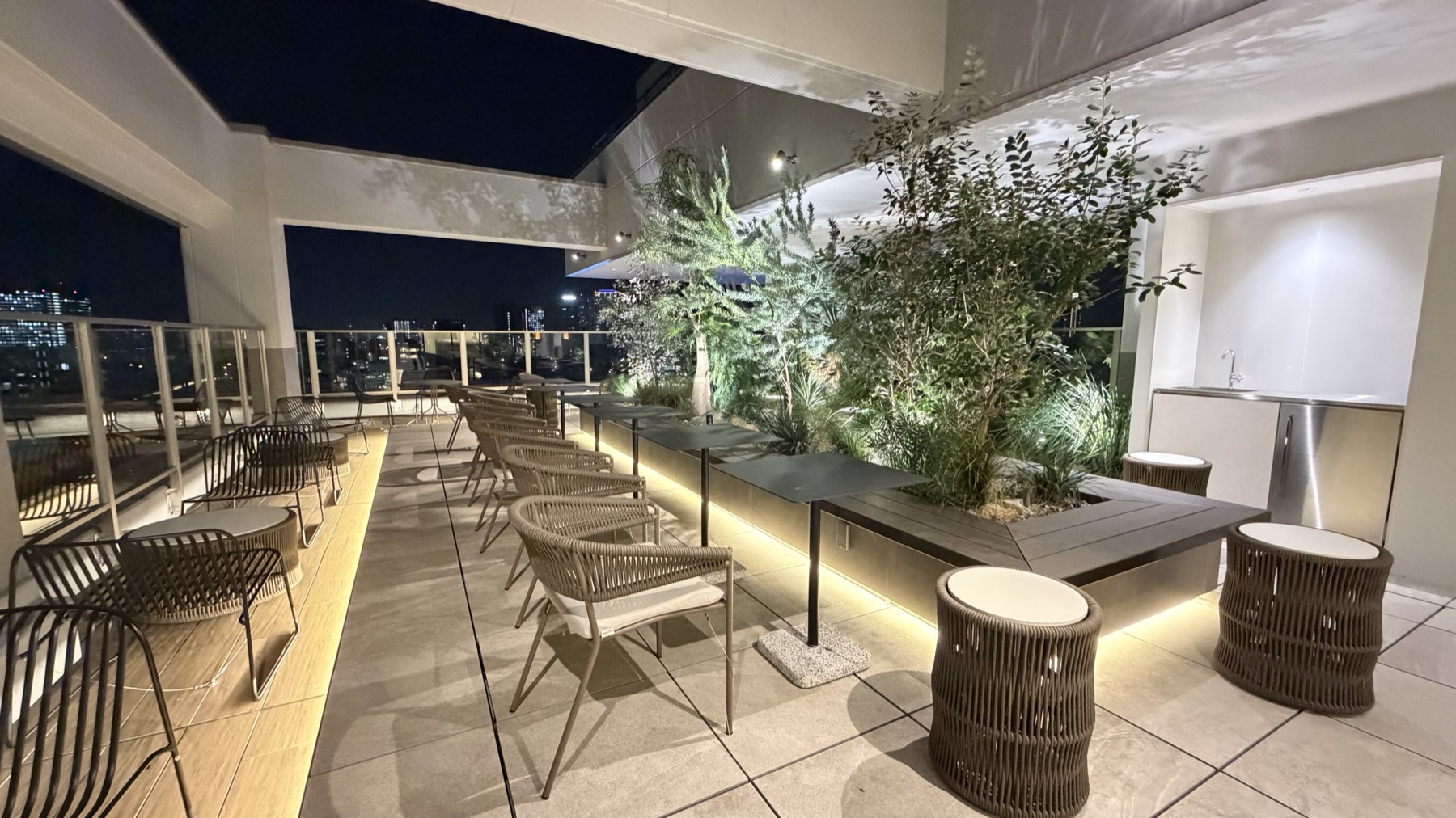 夜のルーフトップテラス。植栽とテーブル席